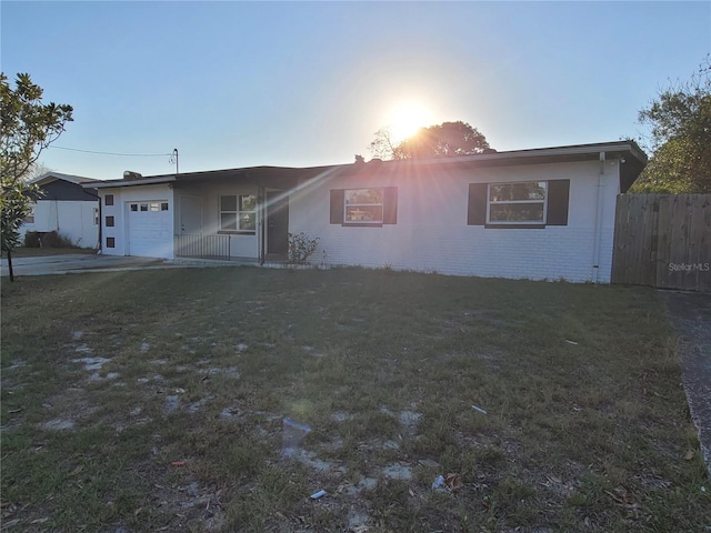 1616 Ferndell Rd, Orlando, FL 32808 - ranch-style house featuring a front yard, a garage, fence, brick siding, and driveway