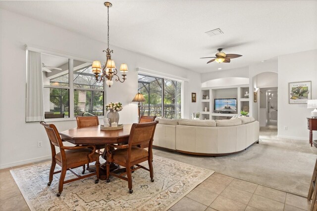 dining area featuring light tile patterned floors, baseboards, built in features, arched walkways, and ceiling fan with notable chandelier