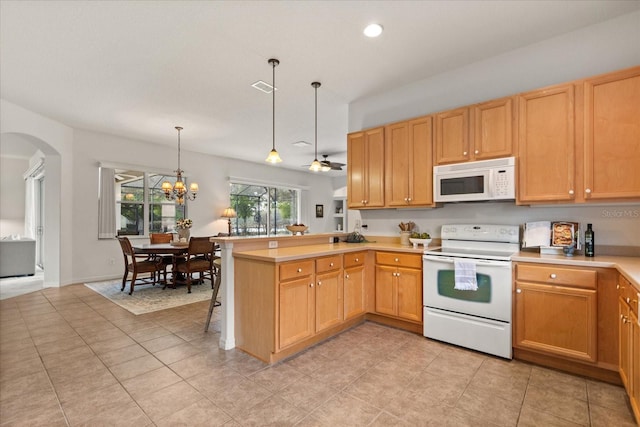 kitchen with a peninsula, white appliances, visible vents, light countertops, and decorative light fixtures