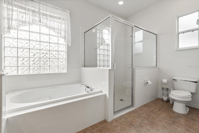 full bathroom with a wealth of natural light, a stall shower, a garden tub, and toilet