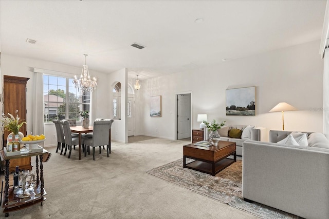 living area featuring a chandelier, light colored carpet, visible vents, and baseboards