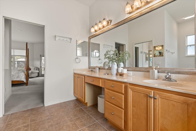 ensuite bathroom featuring double vanity, ensuite bath, tile patterned flooring, and a sink