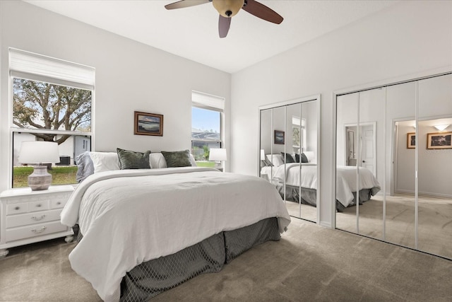 bedroom with carpet, two closets, and a ceiling fan