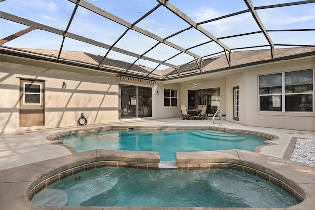 view of pool featuring glass enclosure, ceiling fan, a pool with connected hot tub, and a patio