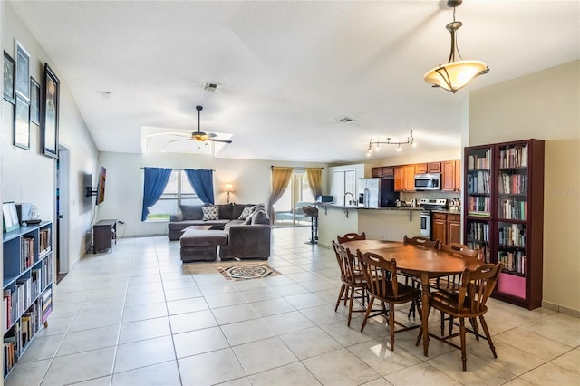 dining area with light tile patterned floors, visible vents, and a ceiling fan