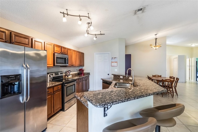 kitchen with lofted ceiling, visible vents, stainless steel appliances, and a sink