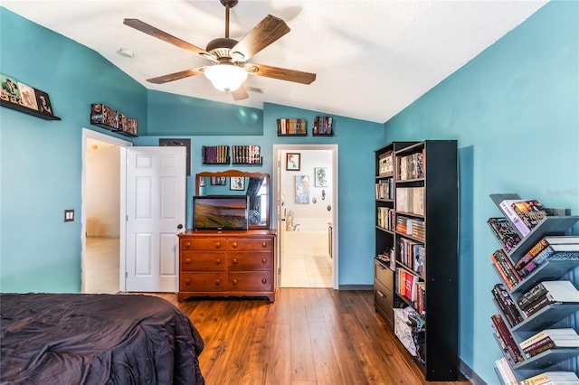 bedroom with lofted ceiling, hardwood / wood-style flooring, ceiling fan, and connected bathroom