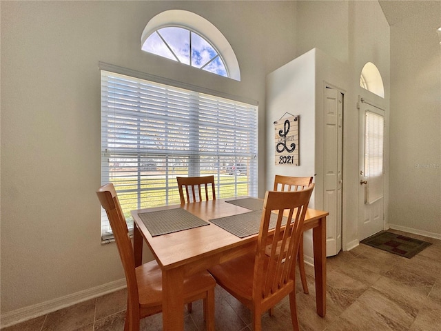 dining space with a high ceiling and baseboards