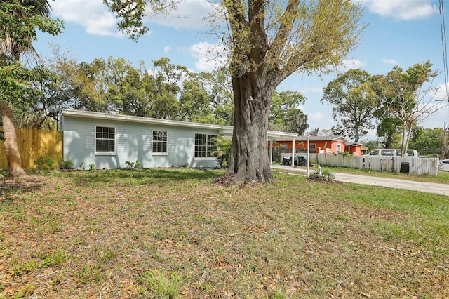 single story home with an attached carport, fence, a front lawn, and concrete driveway