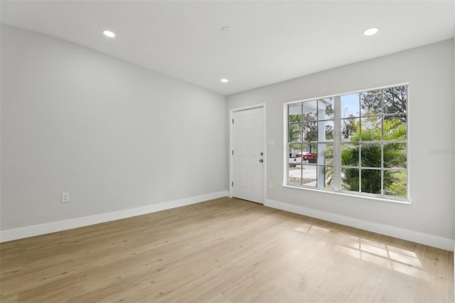 unfurnished room with light wood-type flooring, recessed lighting, and baseboards