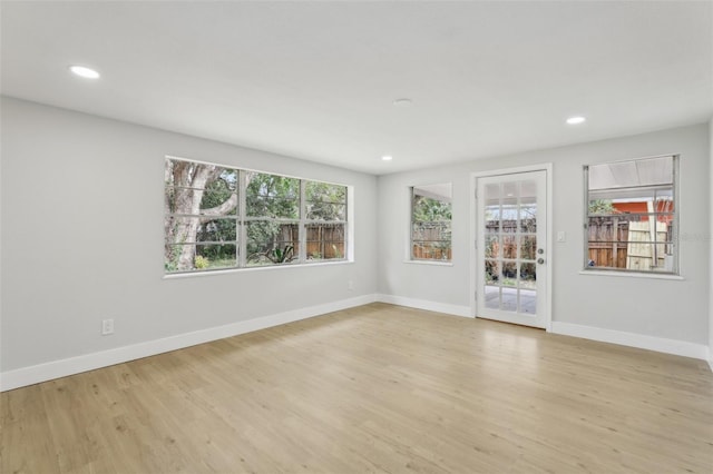 unfurnished room featuring recessed lighting, plenty of natural light, light wood-style flooring, and baseboards