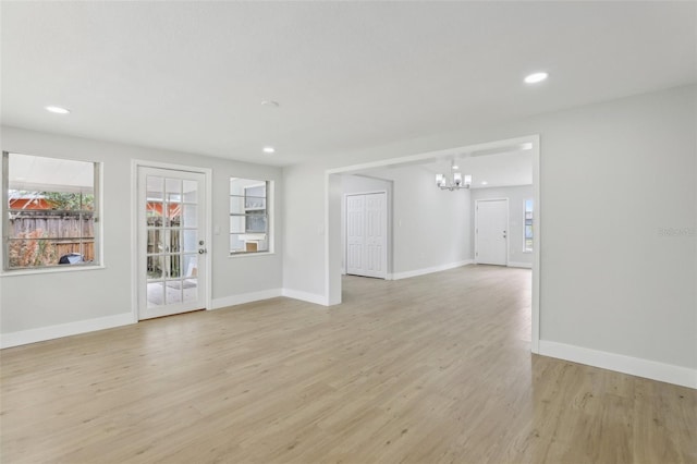 spare room featuring baseboards, light wood finished floors, plenty of natural light, and recessed lighting