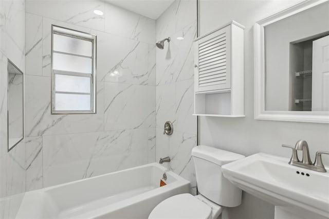 bathroom featuring toilet, shower / bath combination, and a sink