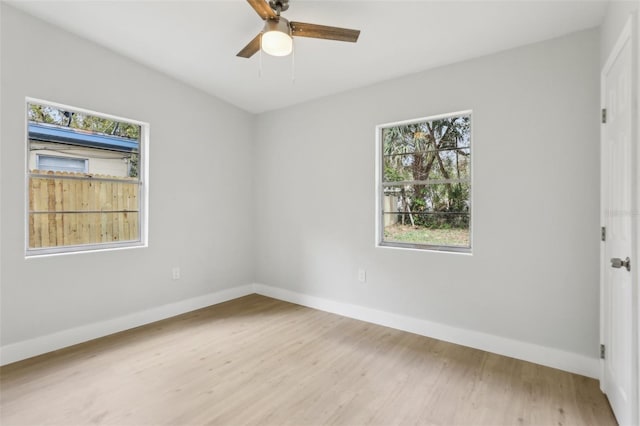 spare room featuring a ceiling fan, baseboards, and wood finished floors