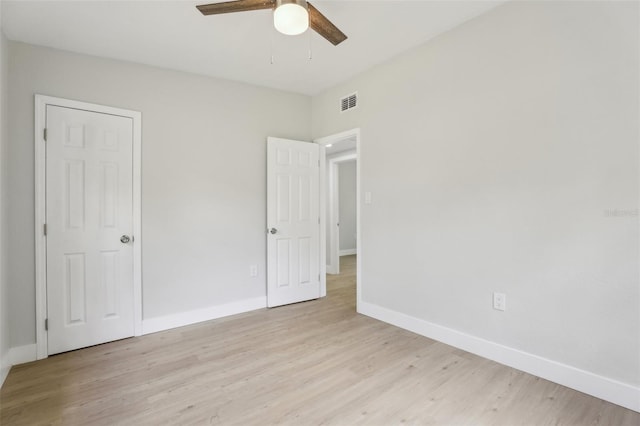 unfurnished bedroom featuring light wood-style floors, visible vents, baseboards, and a ceiling fan