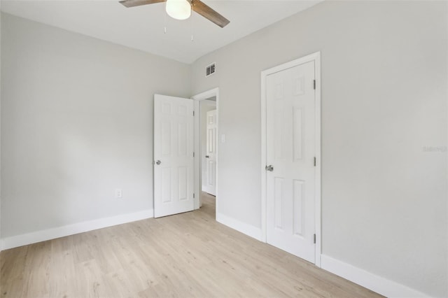 unfurnished bedroom with light wood finished floors, a ceiling fan, visible vents, and baseboards