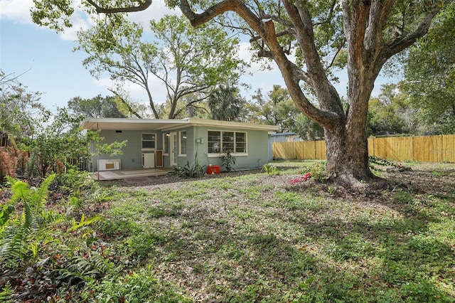 rear view of property featuring fence and stucco siding