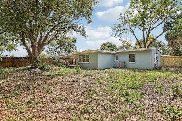 back of house featuring a fenced backyard and central AC