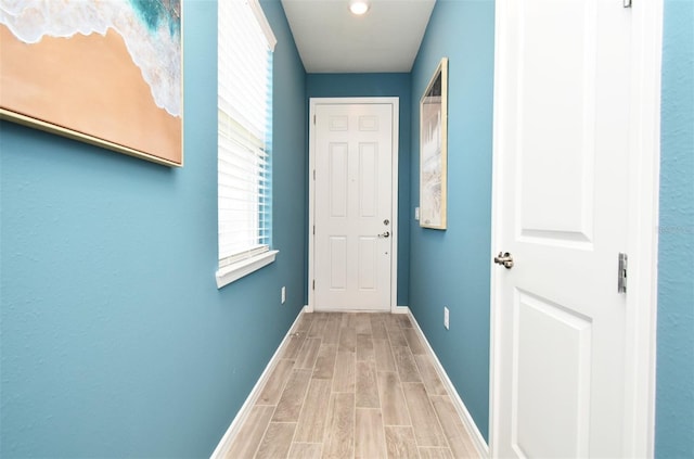 hallway featuring baseboards and wood tiled floor