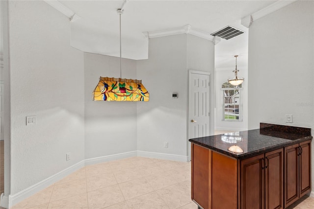 kitchen with baseboards, visible vents, ornamental molding, dark stone countertops, and decorative light fixtures