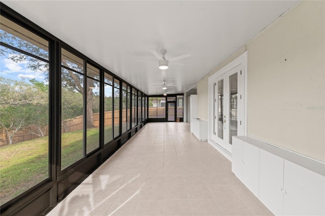 unfurnished sunroom featuring a ceiling fan