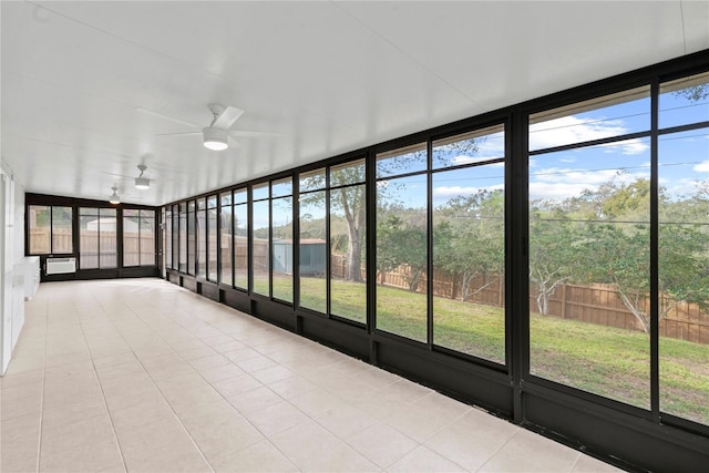 unfurnished sunroom featuring an AC wall unit and a ceiling fan