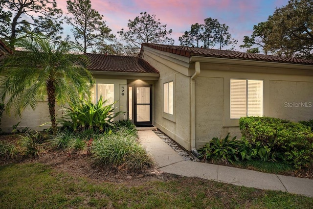 view of front of home featuring a tiled roof and stucco siding