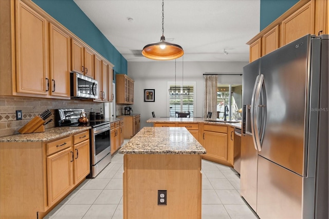 kitchen featuring light tile patterned flooring, stainless steel appliances, a peninsula, a sink, and a kitchen island