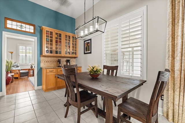 dining space featuring baseboards and light tile patterned flooring