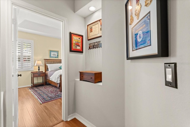 hall featuring wood finished floors and baseboards