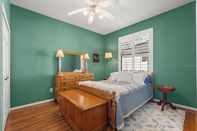 bedroom featuring ceiling fan, baseboards, and wood finished floors