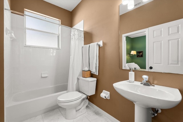 bathroom with baseboards, toilet, tile patterned flooring, shower / bath combination with curtain, and a sink