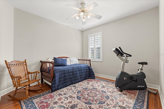 bedroom with wood finished floors, a ceiling fan, and baseboards