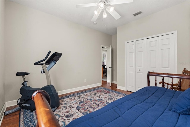 bedroom featuring a ceiling fan, wood finished floors, visible vents, and baseboards