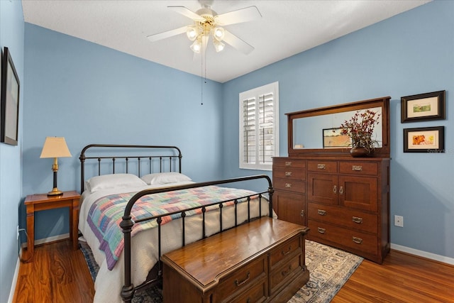 bedroom featuring ceiling fan, wood finished floors, and baseboards