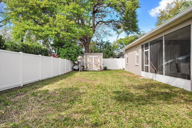 view of yard featuring a storage shed, an outdoor structure, a fenced backyard, and a sunroom