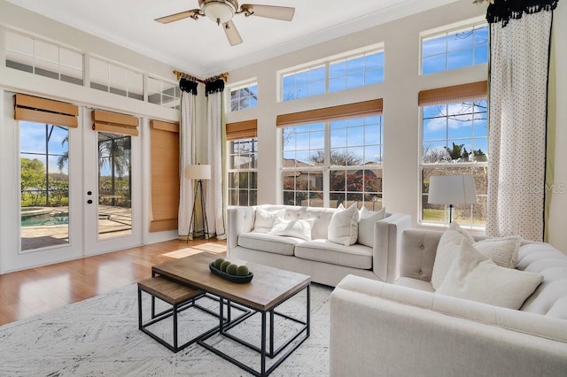 living room with ceiling fan, french doors, wood finished floors, and crown molding