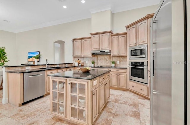 kitchen with tasteful backsplash, glass insert cabinets, under cabinet range hood, built in appliances, and a peninsula