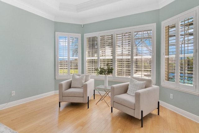 living area featuring crown molding, baseboards, and wood finished floors