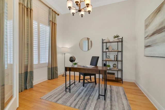 office space featuring an inviting chandelier, wood finished floors, baseboards, and a wealth of natural light