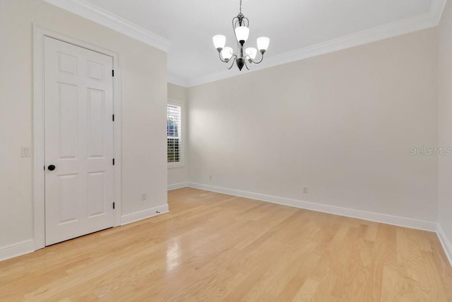 empty room with a notable chandelier, light wood-style flooring, baseboards, and ornamental molding