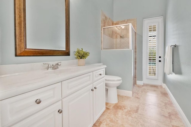 bathroom featuring vanity, toilet, baseboards, and a stall shower