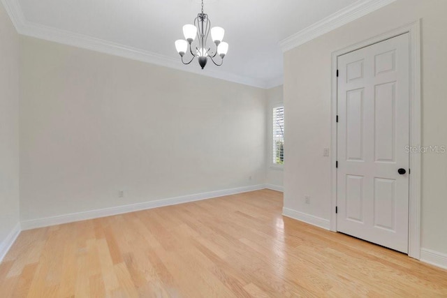 spare room with light wood-type flooring, baseboards, a chandelier, and crown molding