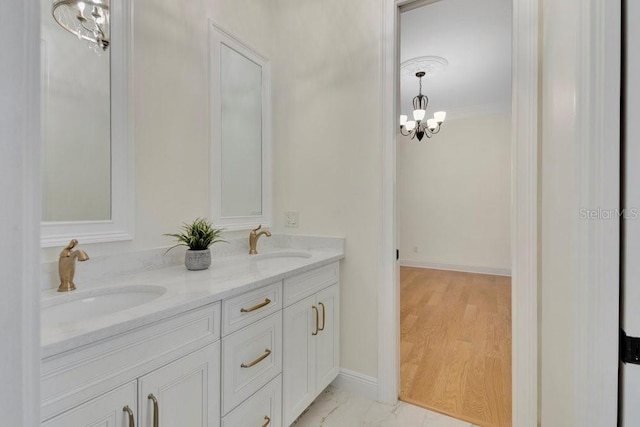 full bath with a sink, baseboards, marble finish floor, and double vanity