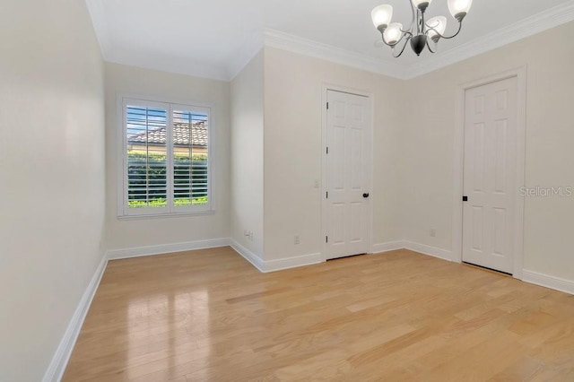 entrance foyer with light wood-type flooring, baseboards, a chandelier, and crown molding