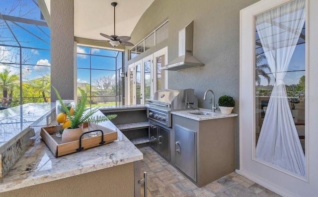 view of patio / terrace with grilling area, ceiling fan, glass enclosure, an outdoor kitchen, and a sink