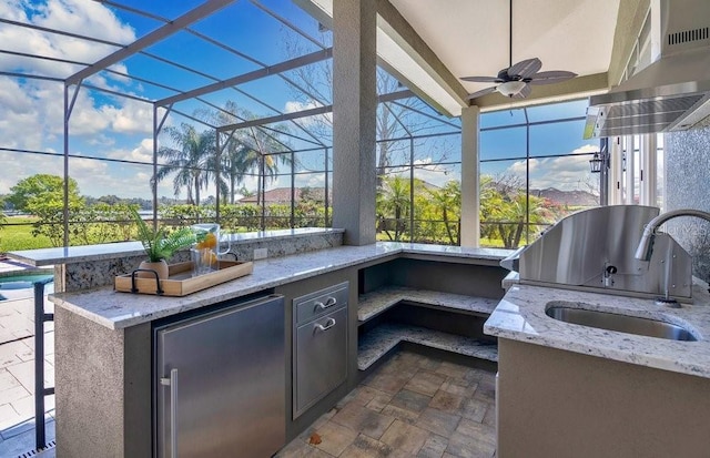 view of patio / terrace featuring a ceiling fan, an outdoor kitchen, a sink, a lanai, and a grill