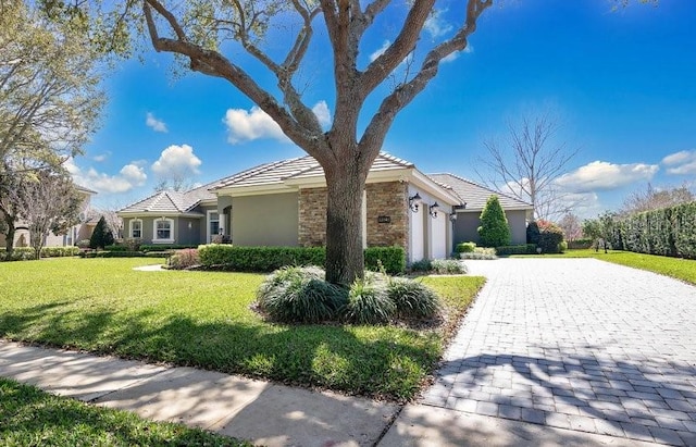 view of home's exterior with a lawn, stucco siding, decorative driveway, stone siding, and an attached garage