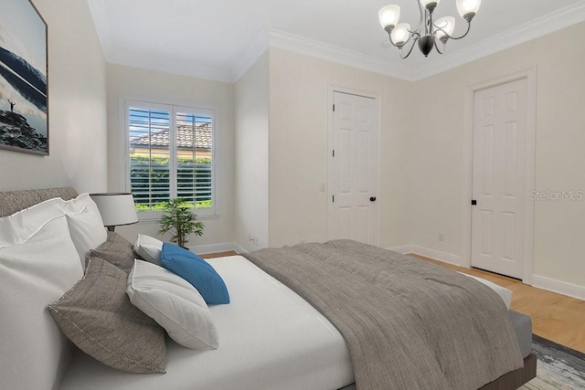 bedroom with a notable chandelier, wood finished floors, and ornamental molding