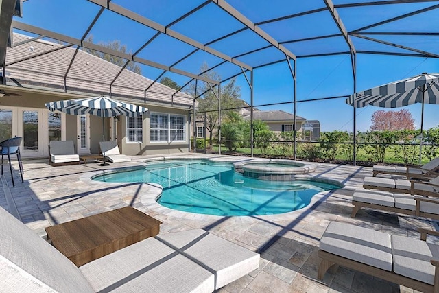 view of pool featuring glass enclosure, a pool with connected hot tub, and a patio area